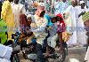 Next picture :: A man rides a motorbike with his children after prayers
